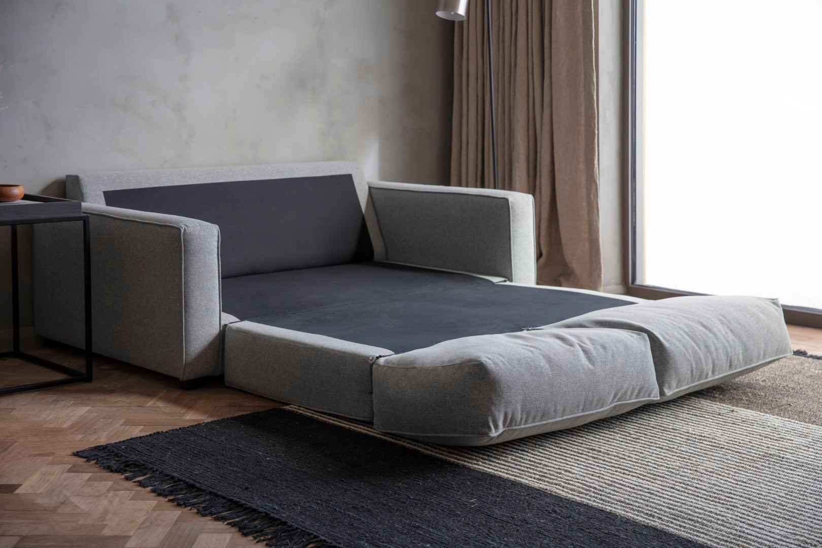 Grey and Black Double Sofa as a bed in the room