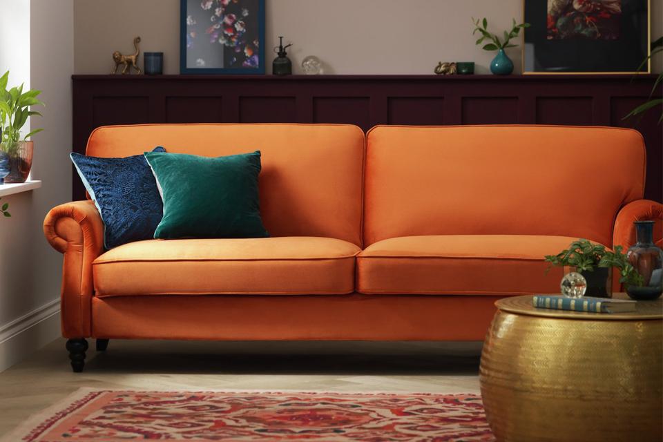 Orange Sofa Bed with Two Cushions on it in the Living Room
